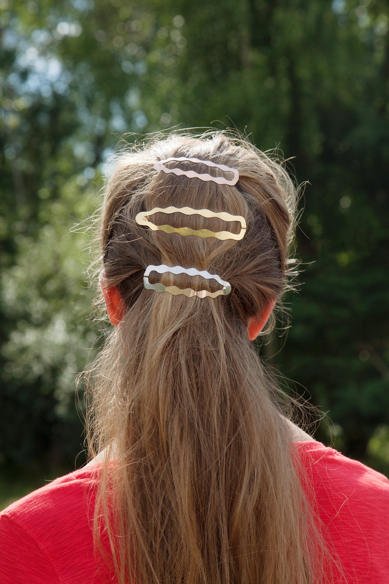 Back view of model wearing her hair in a low ponytail with designer hair clips Frances and Dione