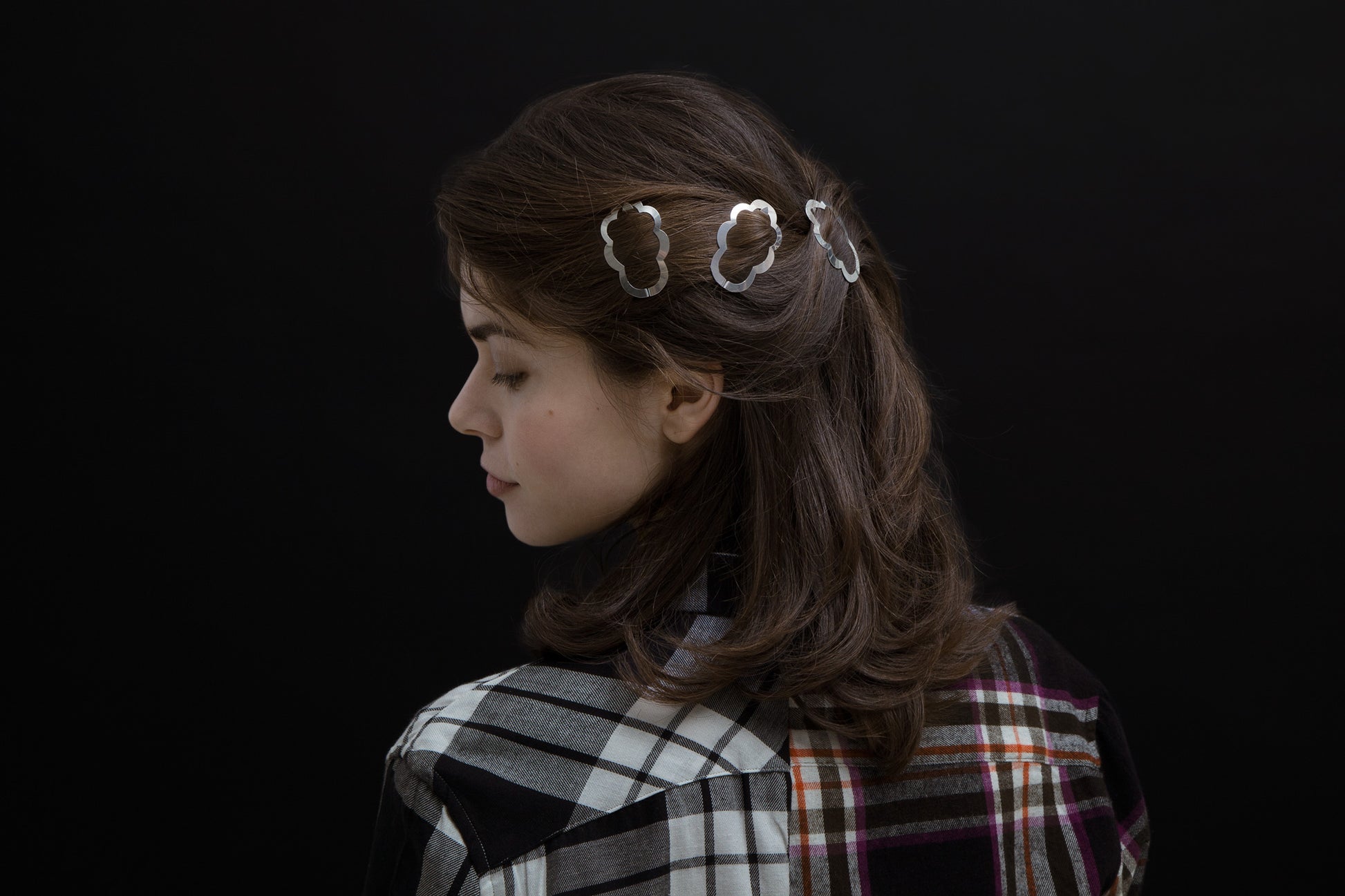 Side view of model wearing her hair in a half updo secured with designer hair clips Camille by Clinq