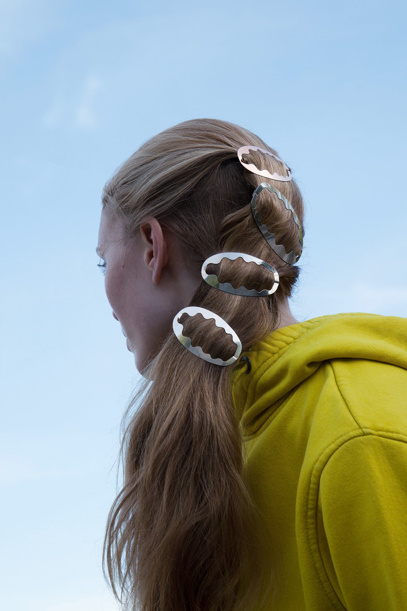 Model wearing her high ponytail styled with designer hair clips Ida and Zelda