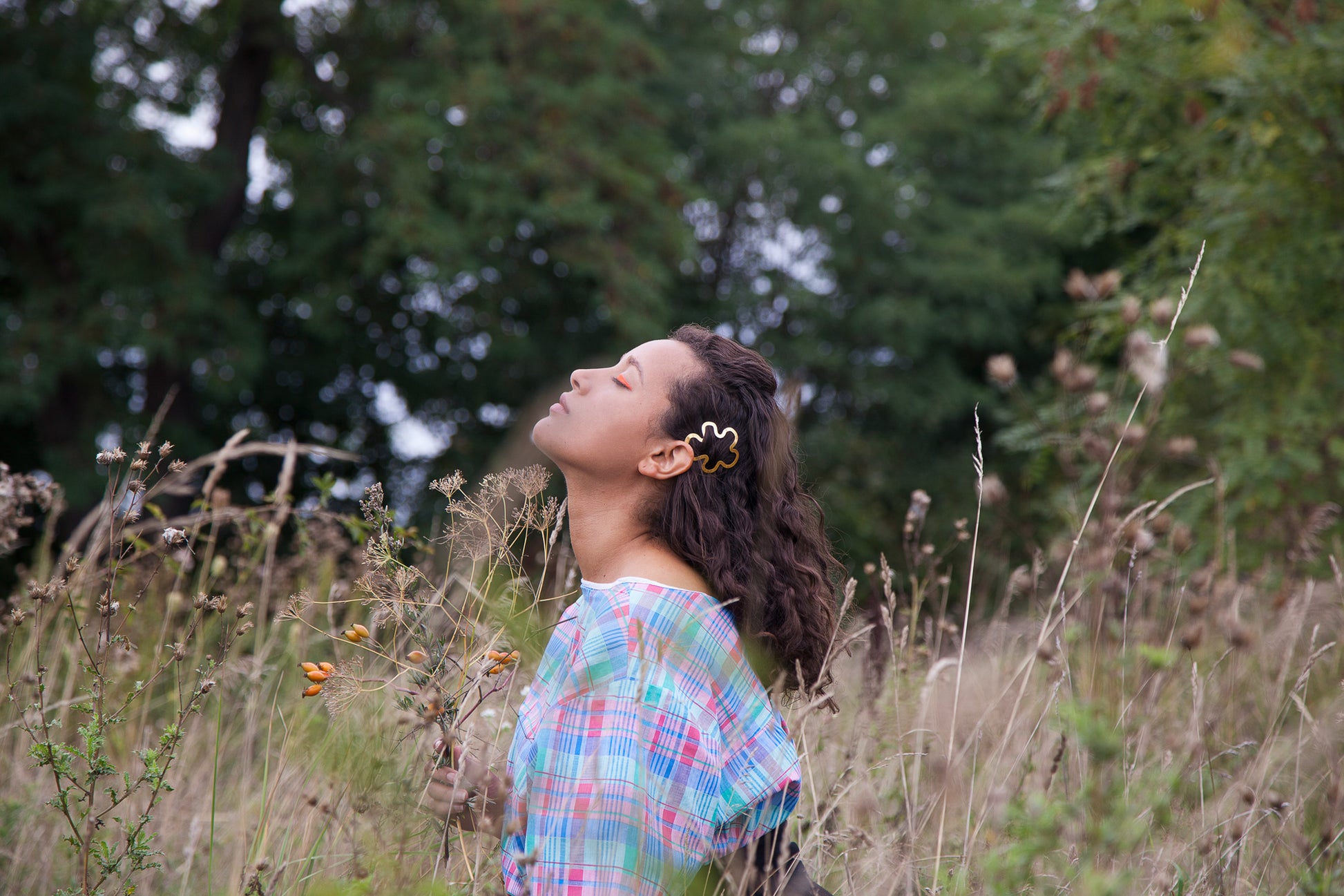 Model looking up with her curly hair down accented with designer hair clip Hilma