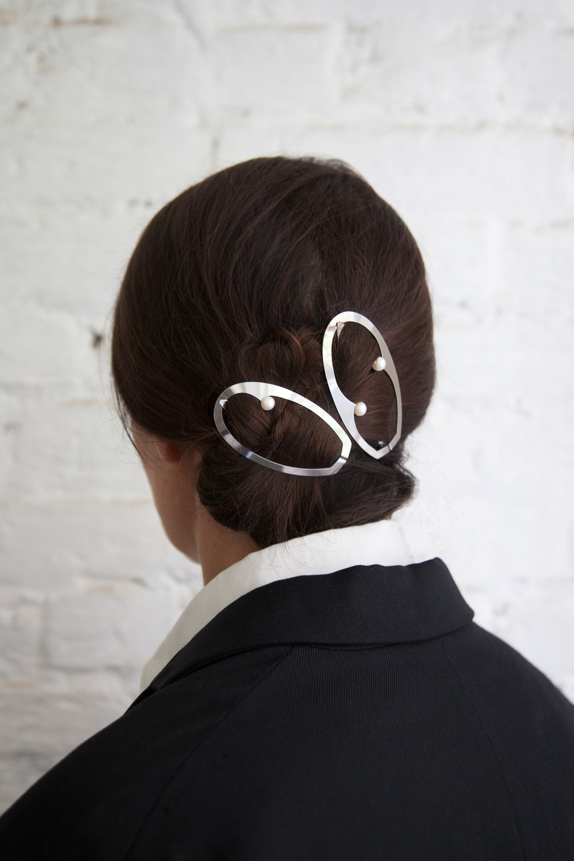 A hairstyle for special occasions. Low twisted bun with designer hair clips Elsa and Mae by Clinq in silver plated with pearls