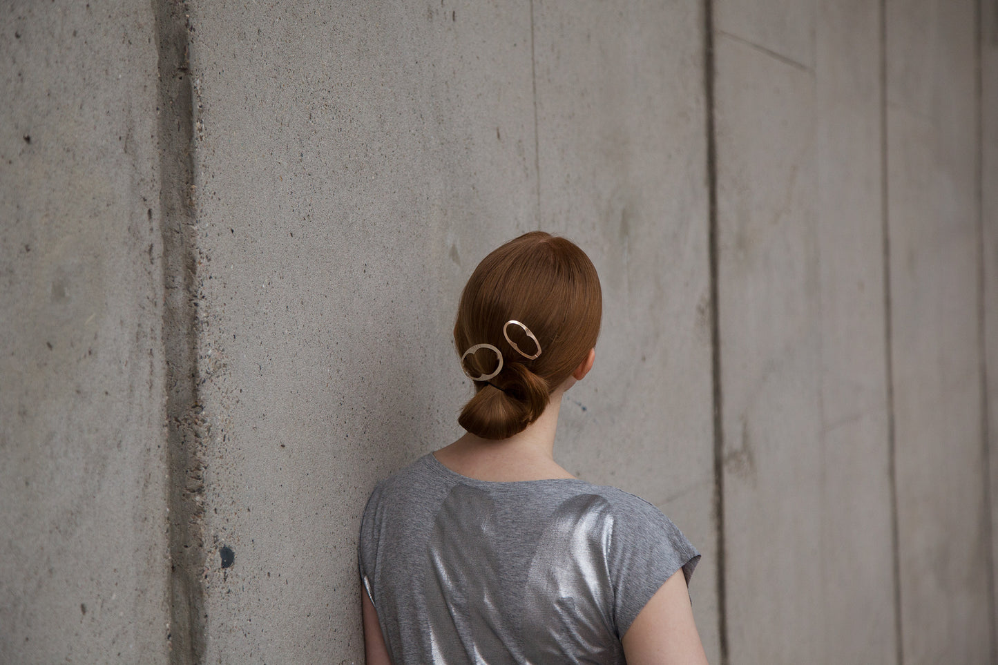 Back view of model wearing her hair in a low ponytail styled with designer hair clips Enid and Jane