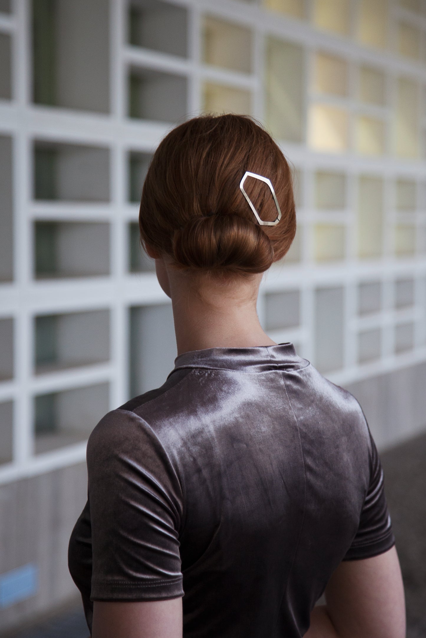 Model wears asymmetrical designer hair clip ALICE which adds an edgy twist to a neat low bun.