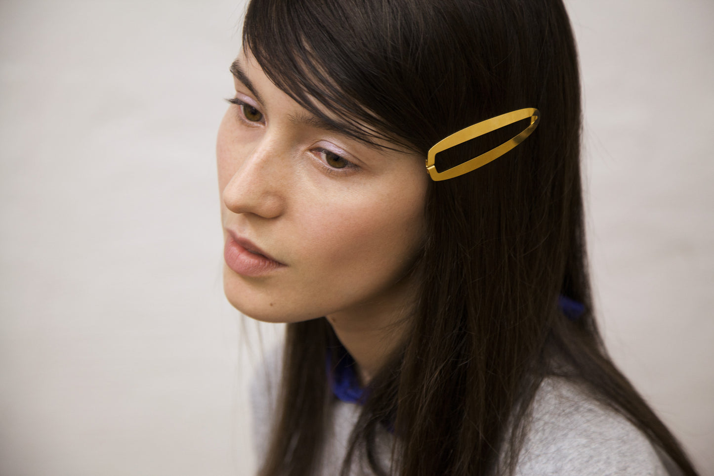 Side view of model wearing designer hair clip Gaia in gold-plated by Clinq