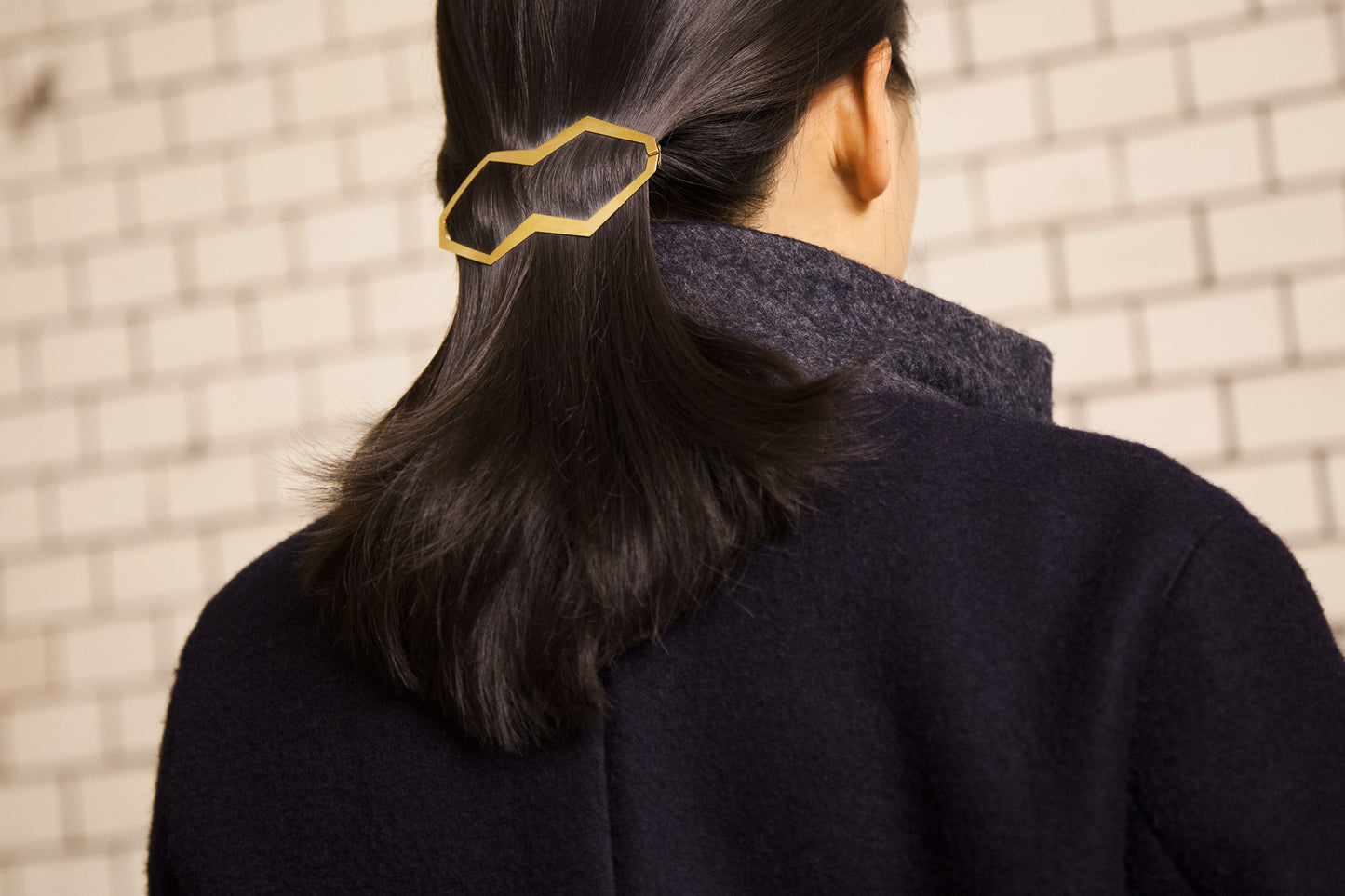 Close up of low ponytail secured with designer hair clip Hanya