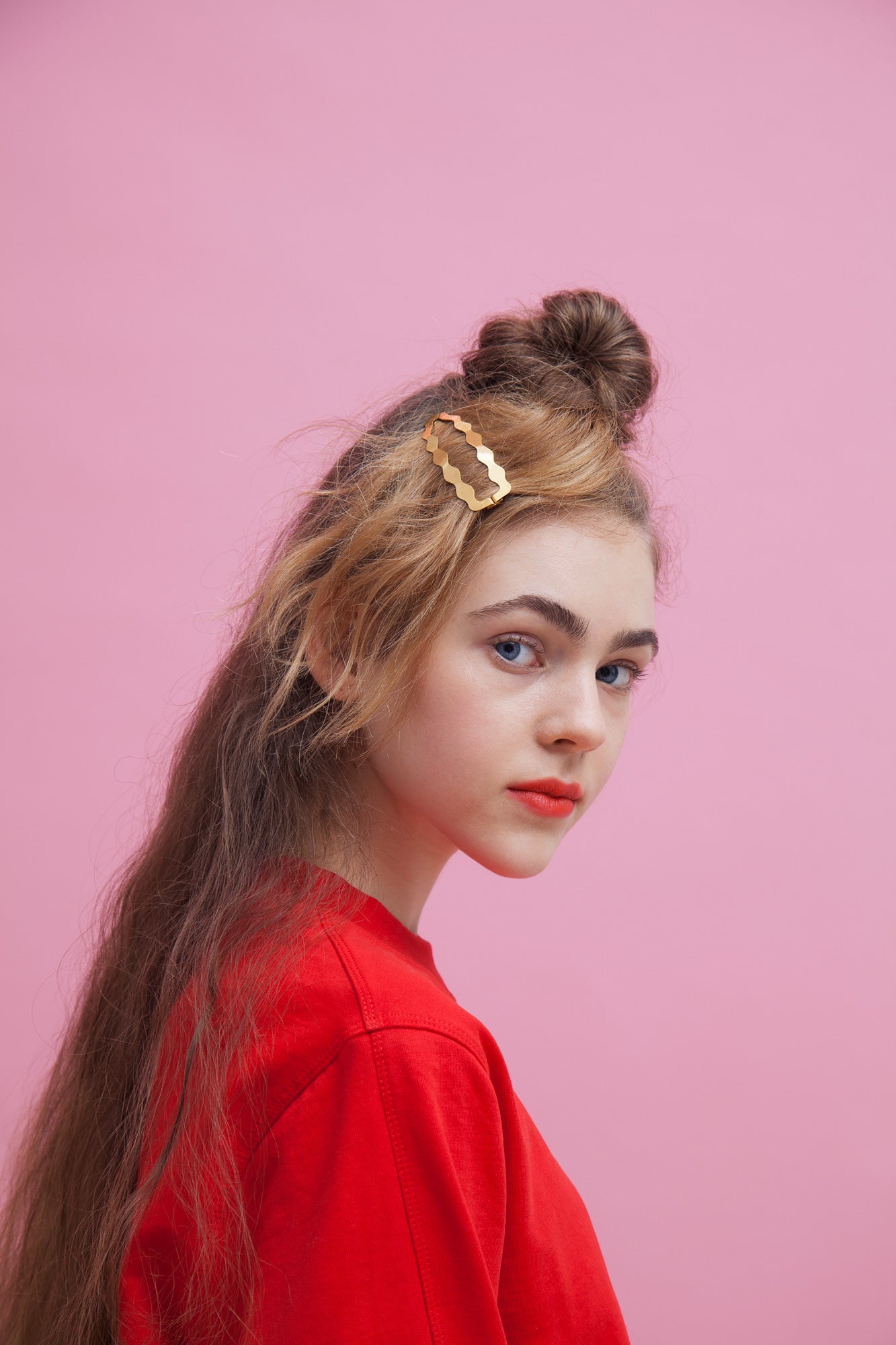 Designer hair clip Dione in gold plated worn on a side parting with a top knot