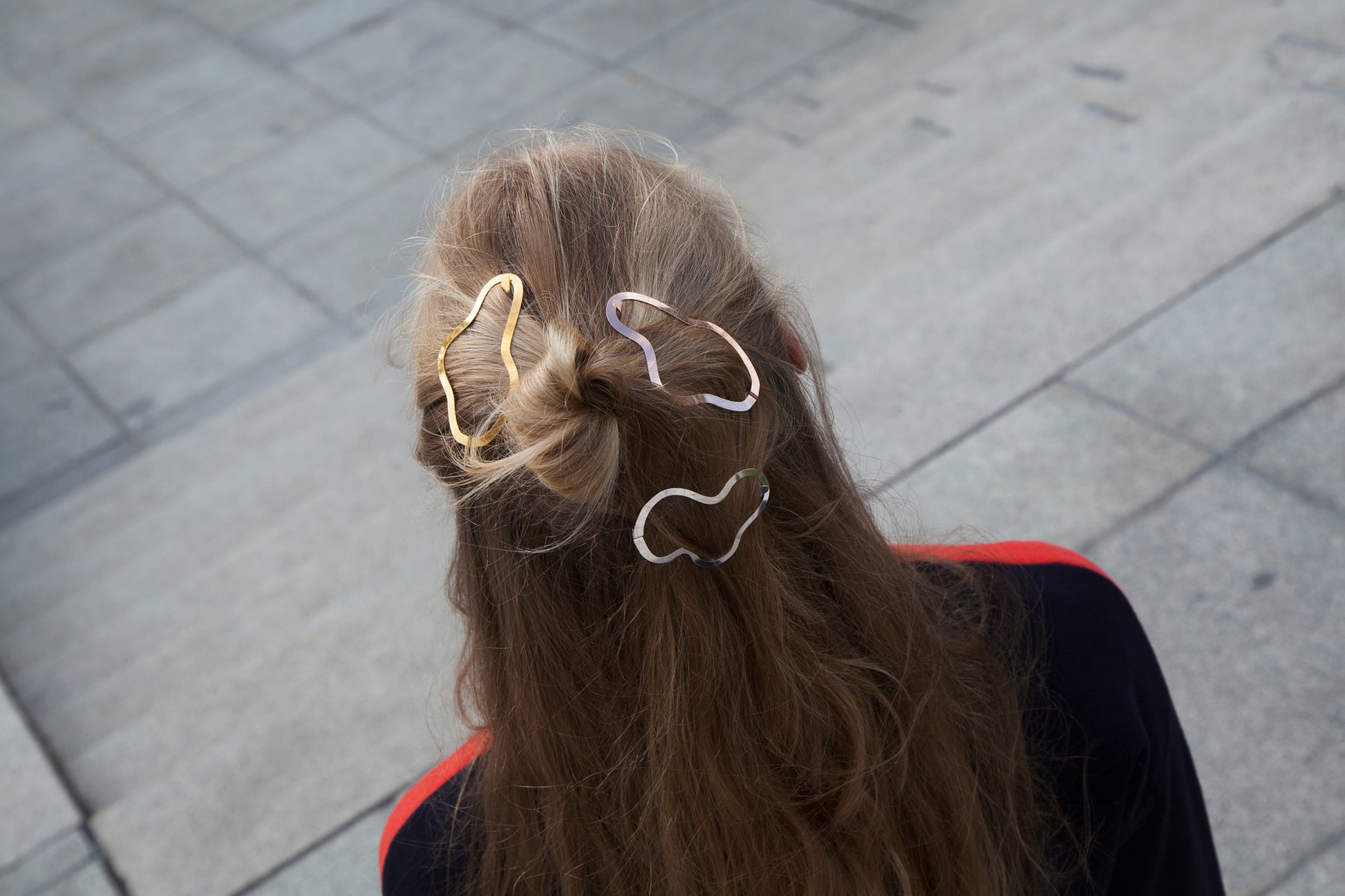 Top view of model wearing a half up top knot accessorized with designer hair clip Simone and Greta
