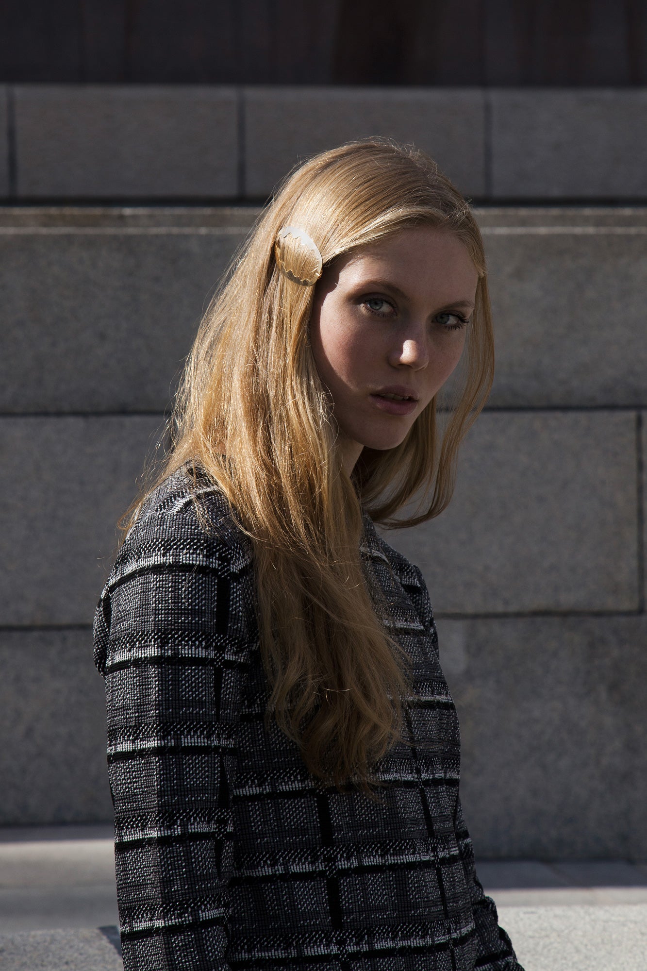 Model looking into the camera with her long hair down accessorized with designer hair clip Ida.
