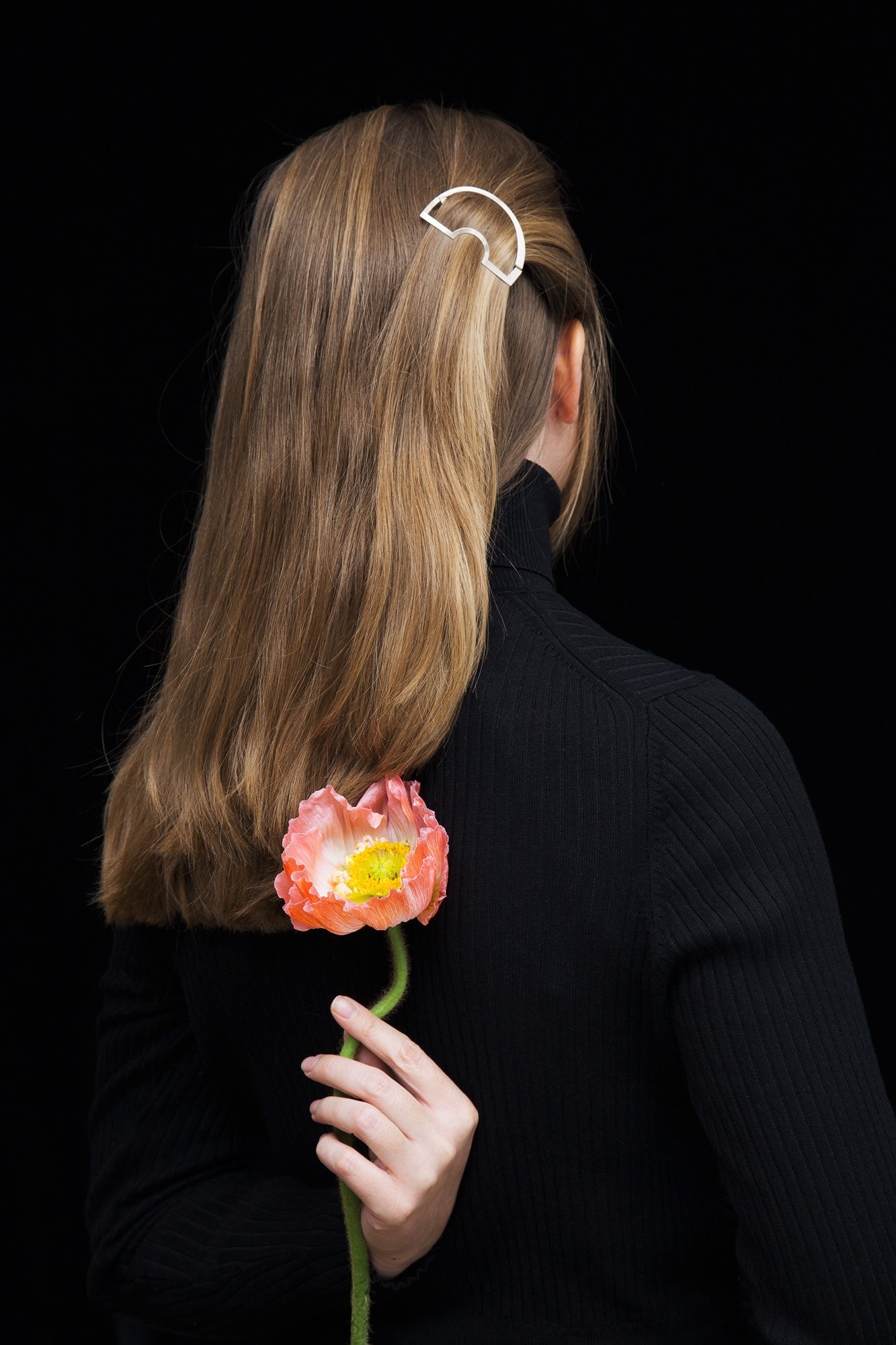 Back view of model wearing her hair down with one strand of hair accented with designer hair clip Carlina by Clinq