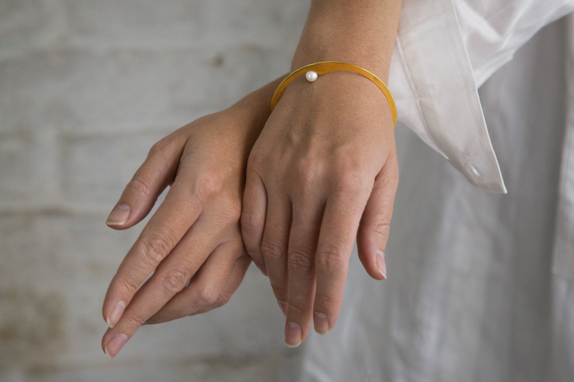Close up of models hands showing the designer bangle bracelet Elea by Clinq