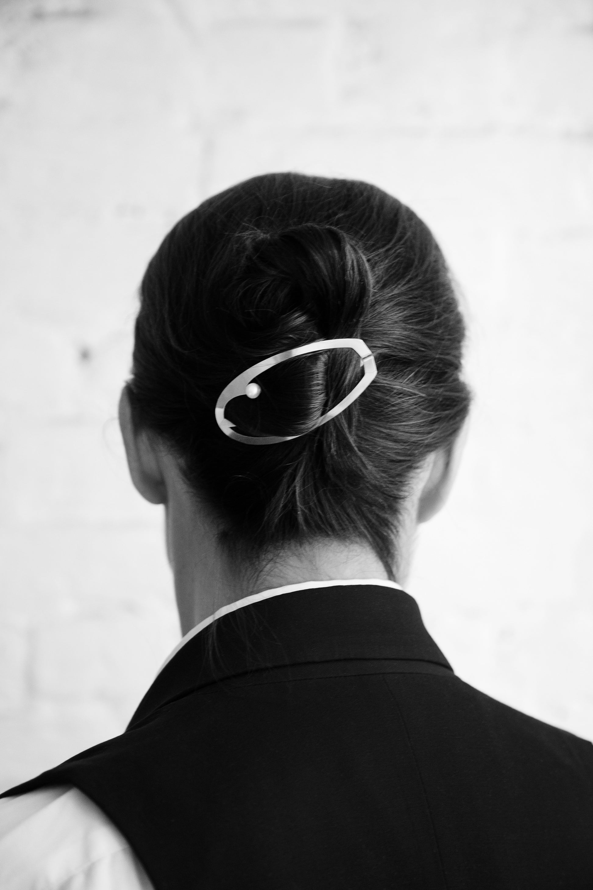 Model wearing a low chignon secured with designer hair clip ELSA by Clinq with a cultured freshwater pearl