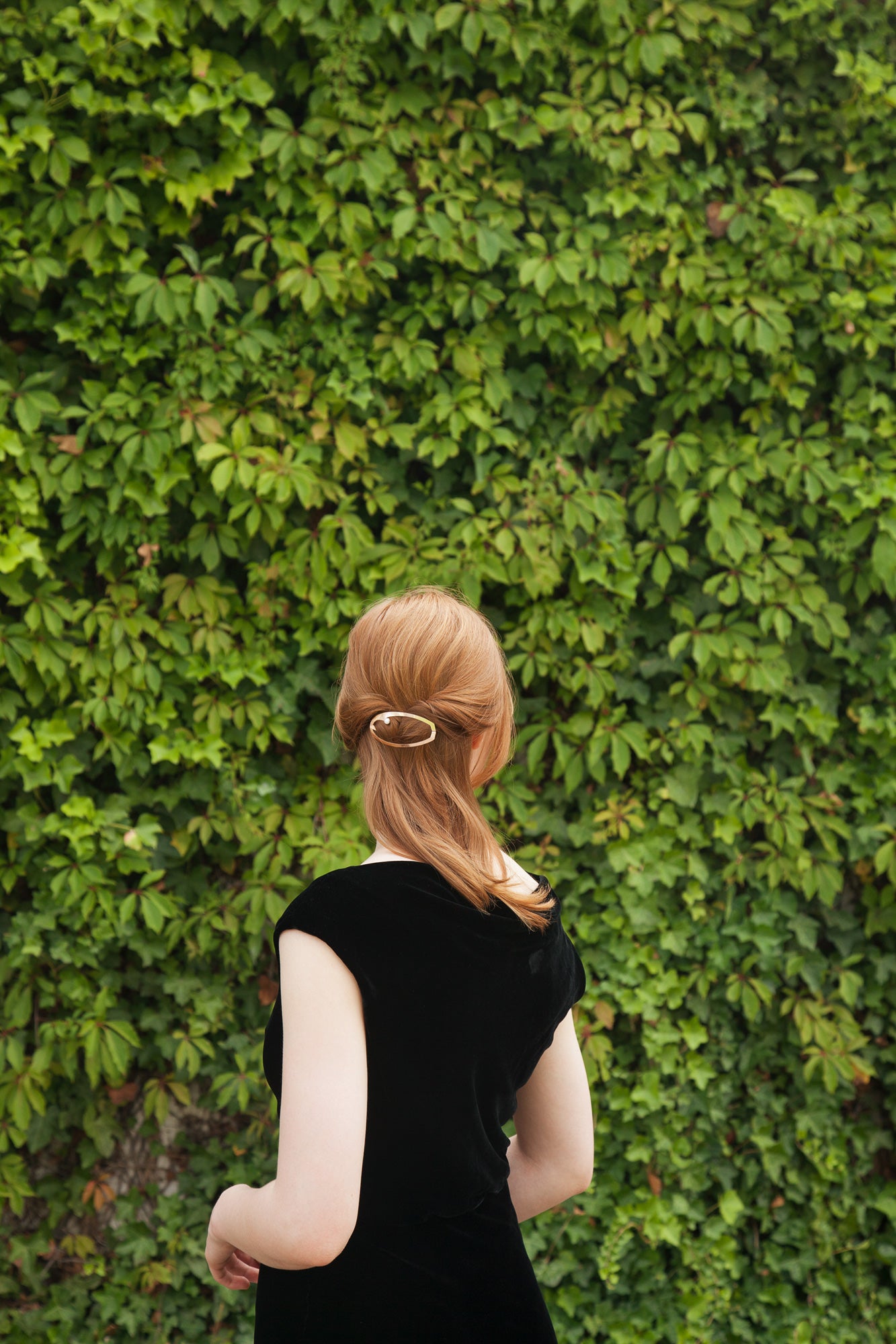 Back view of model wearing her hair in a half updo accessorized with designer hair jewelry ELSA by Clinq