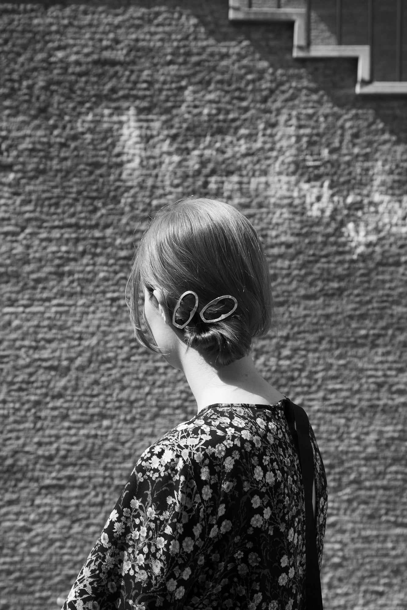 Model featuring a low twisted chignon with designer hair clips Enid by Clinq