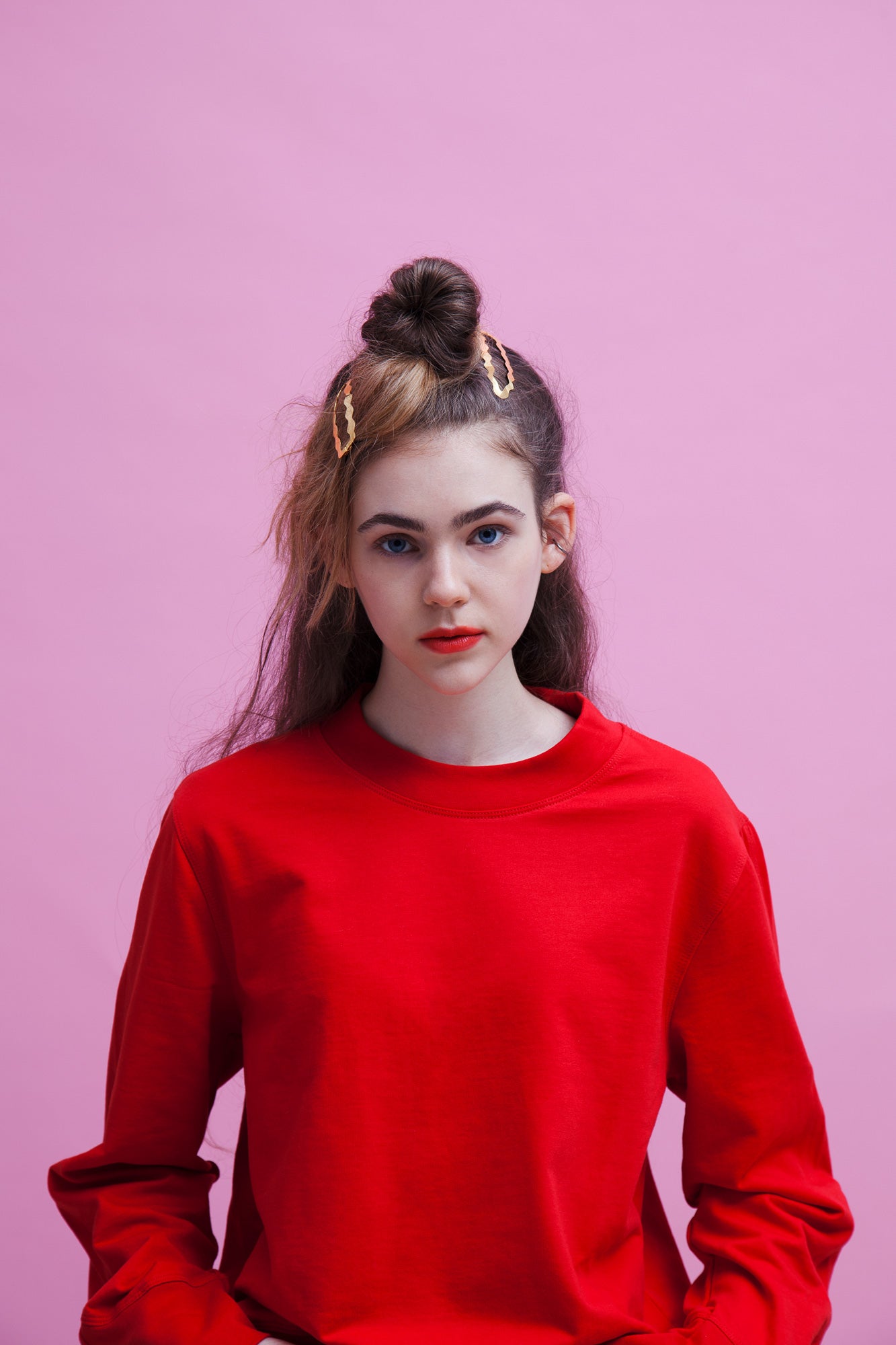 Portrait of model wearing her hair in a half updo styled with designer hair clips Dione on each side 