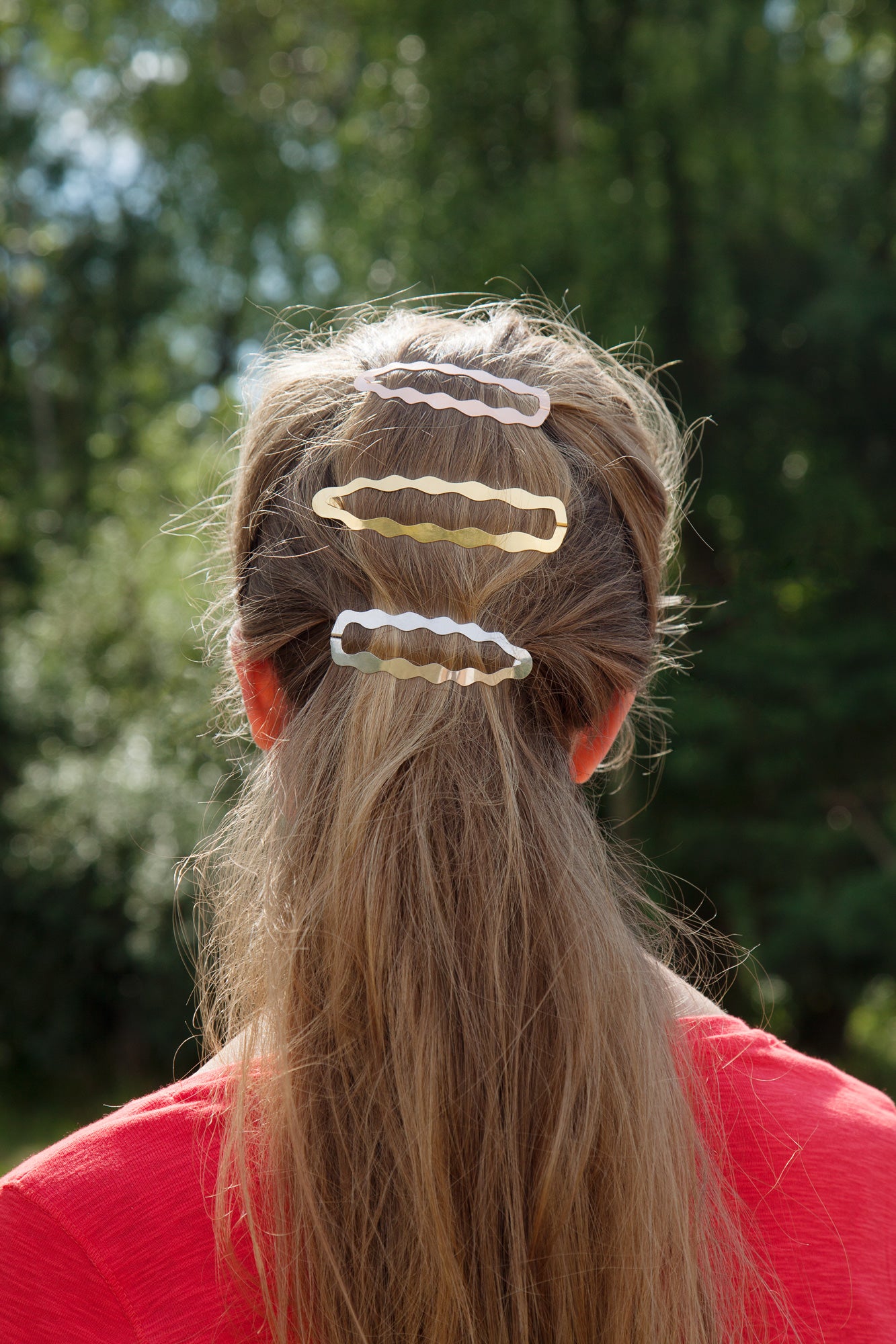 Back view of model wearing her hair in a low ponytail with designer hair clips Frances and Dione 