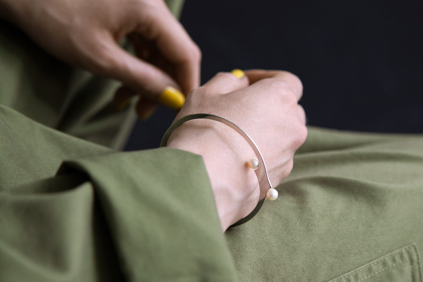 Model presenting the April designer bangle bracelet by CLINQ in silver-plated with cultured fresh water pearls