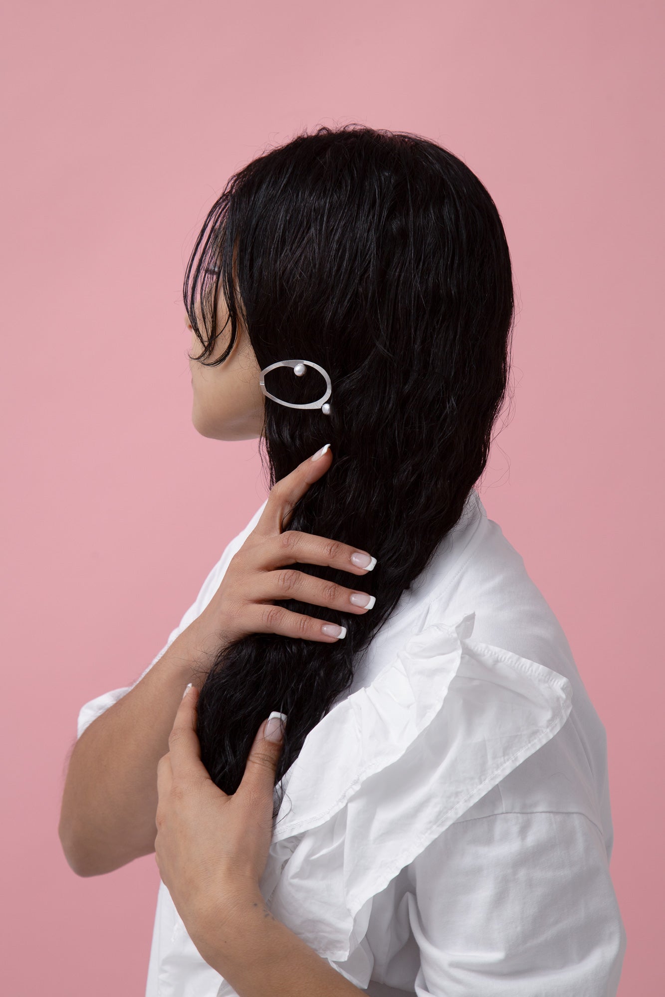 Model wearing a stainless steel hair clip embellished with silver-tone shell pearls
