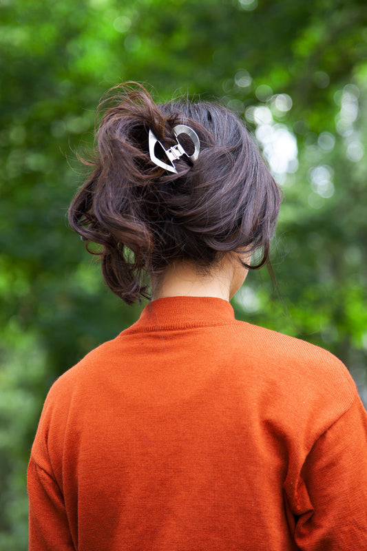 Model wearing up do with asymmetrical claw clip Pia made from mirror polished stainless steel 