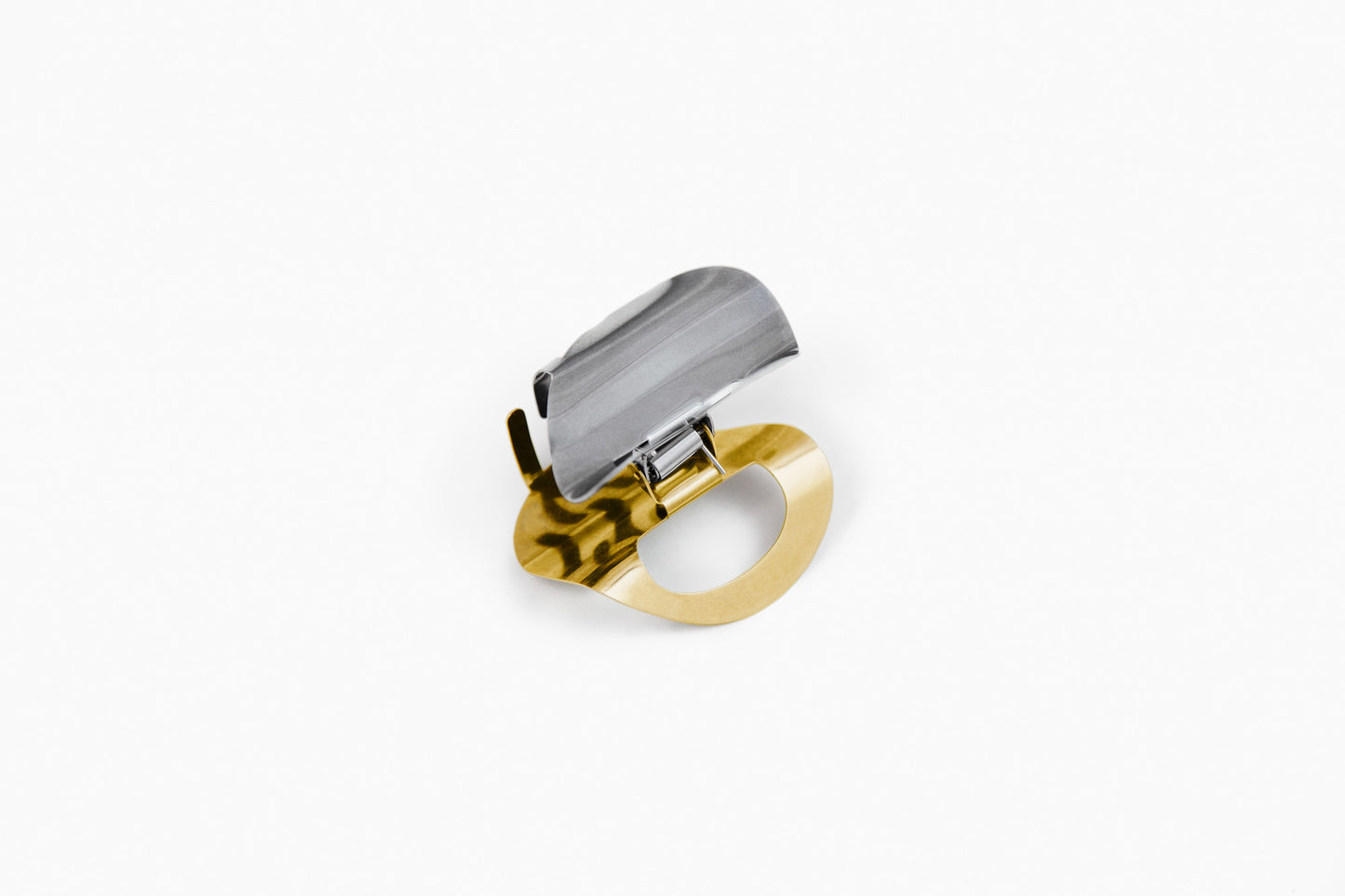Product shot of the sculpted claw clip SANA made from mirror polished stainless steel with two-tone colour silver-tone and gold-plated