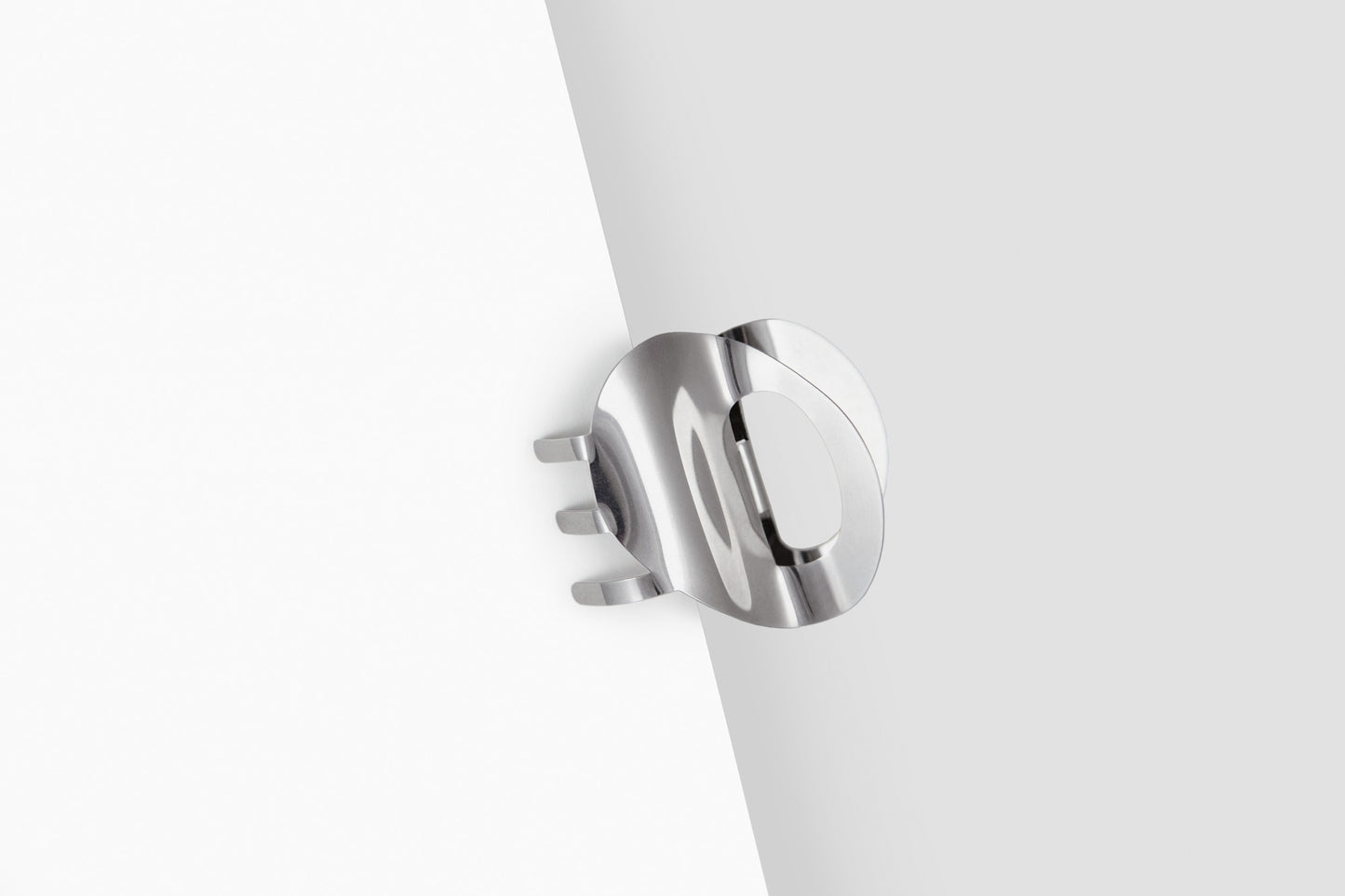 Clipped in product shot of the sculpted claw clip SANA made from mirror polished stainless steel