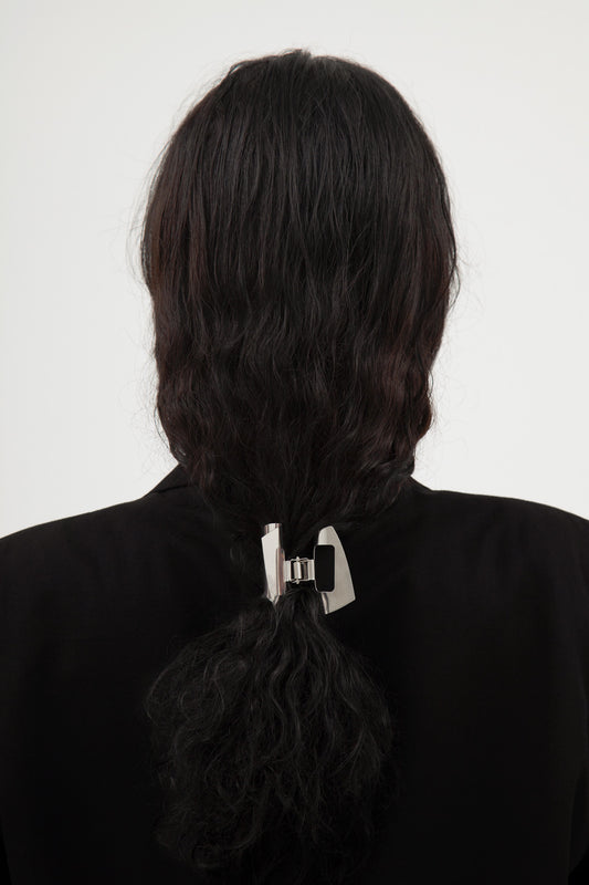 Person with black hair tied in a ponytail with designer stainless steel claw clip MIRA by CLINQ 