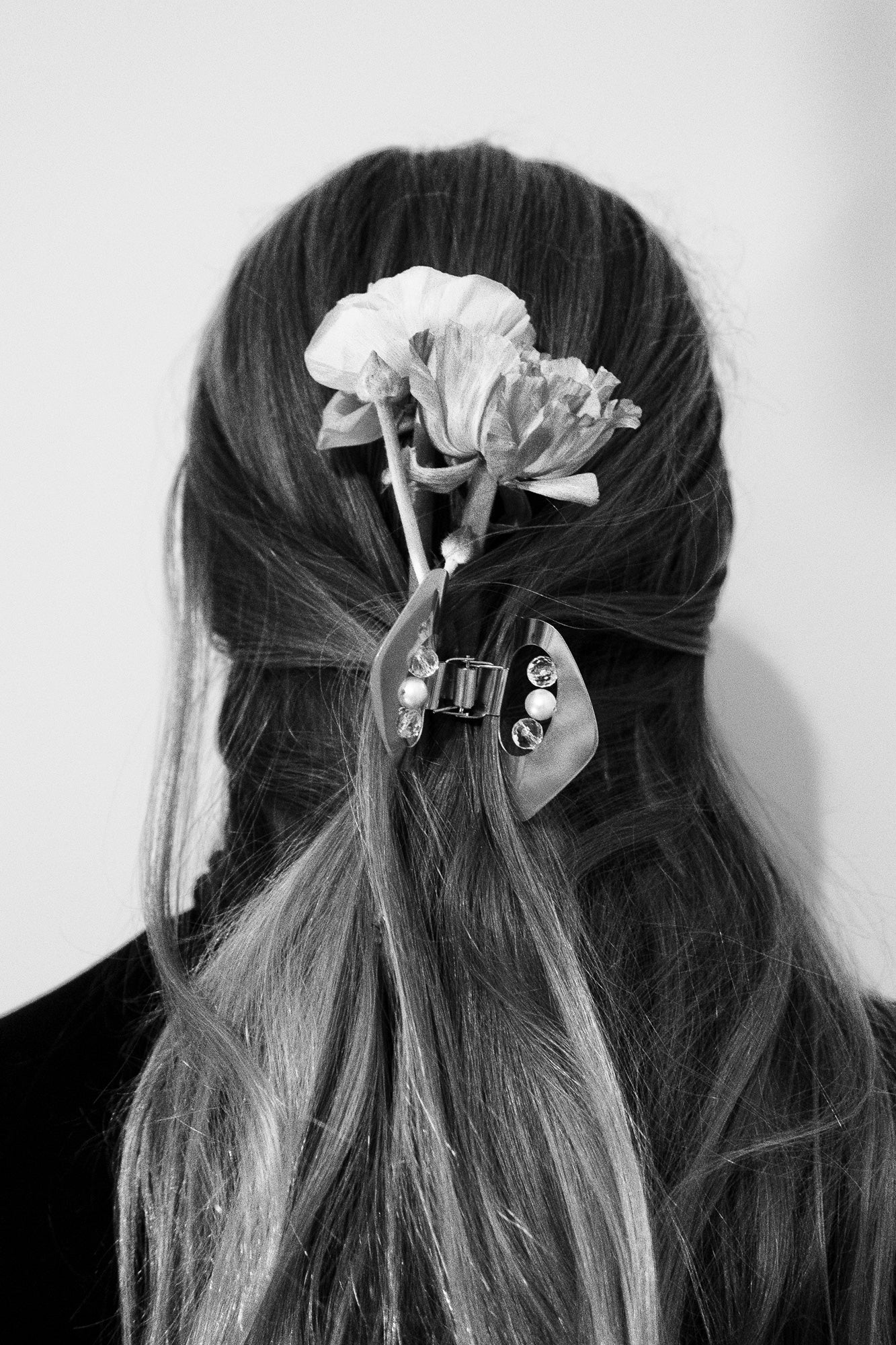 Womwn with her hair styled in a half-up, half-down look accented with a gold plated claw clip with rock crystals and freshwater pearls