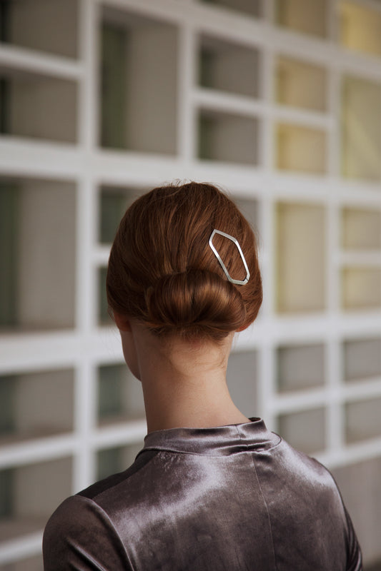 Geometric and asymmetrical, the ALICE designer hair clip adds an edgy twist to a neat low bun.