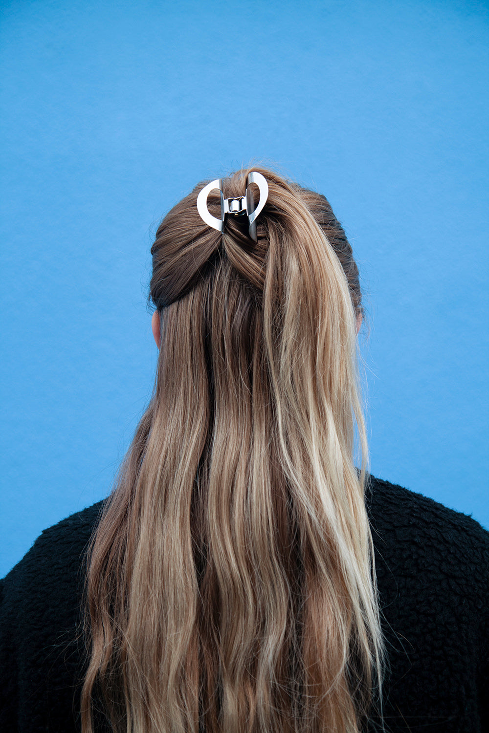 Model wearing a twisted half up do secured with the luxurious sculpted claw clip SANA 