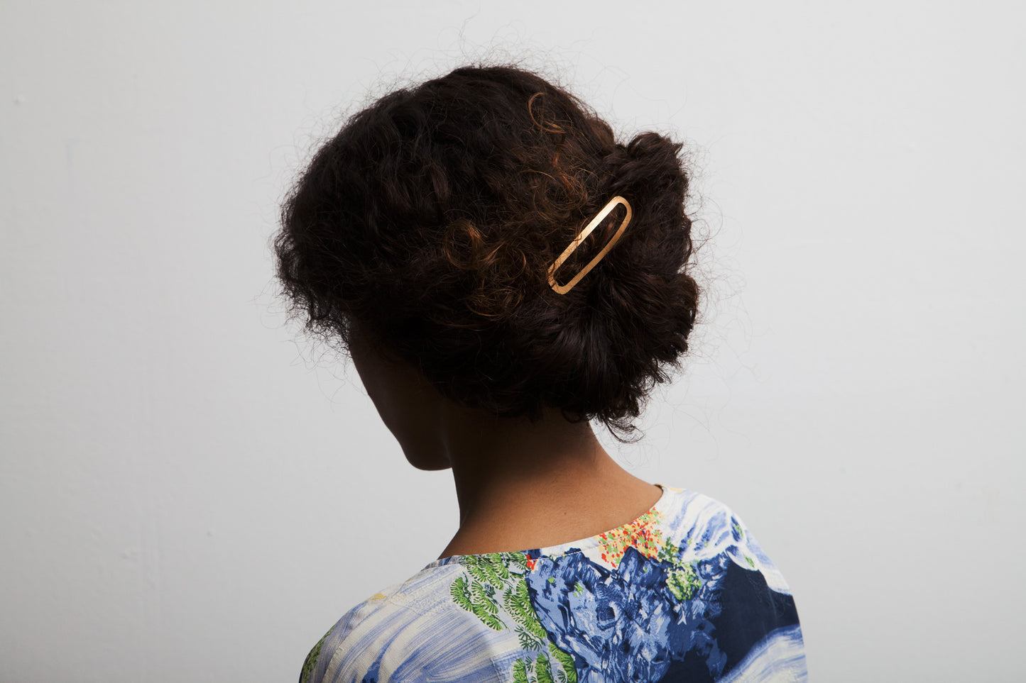 Model wears her hair in a loose low bun, secured with a gold plated designer hairclip Ada. Handmade by CLINQ.