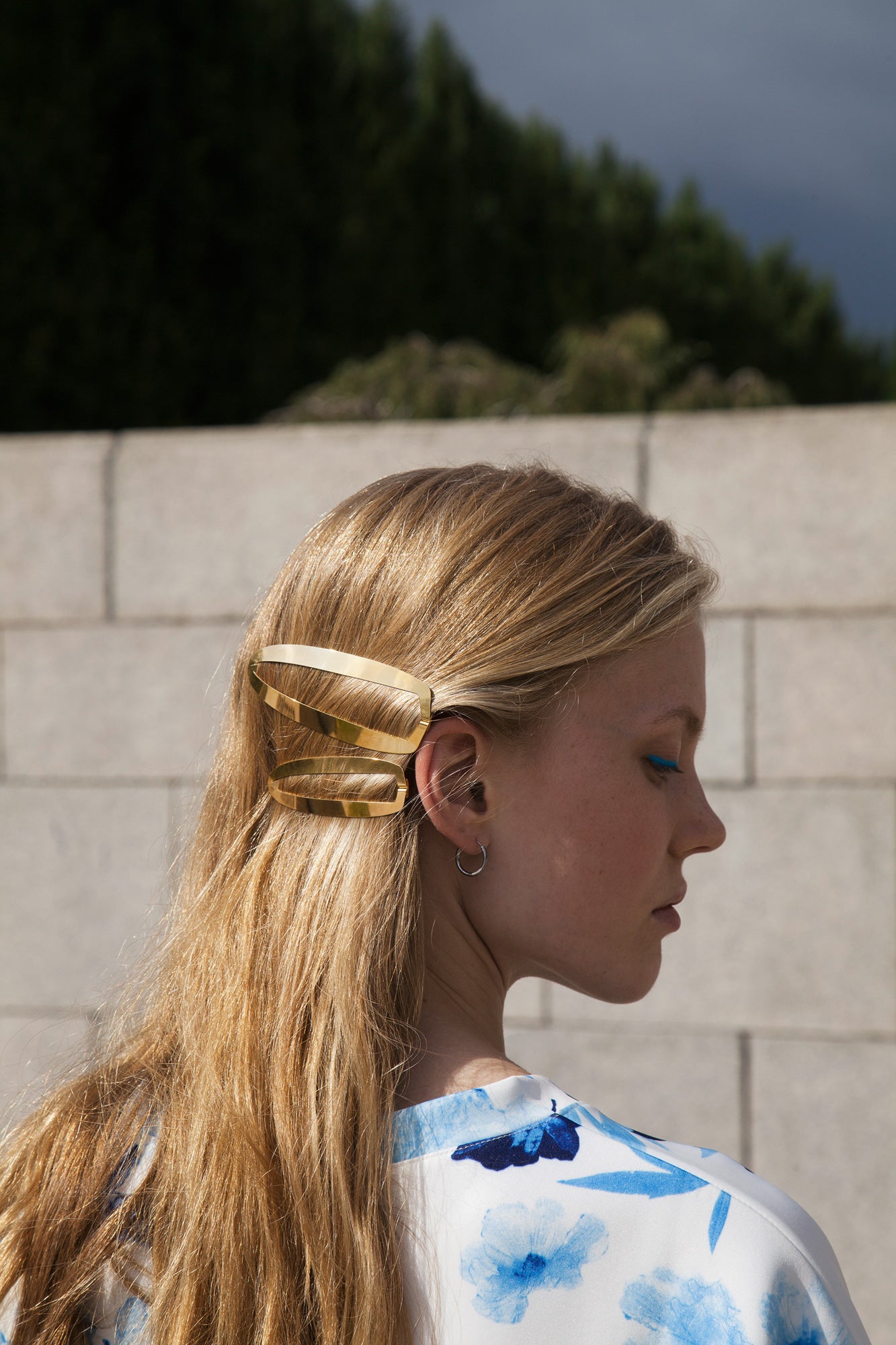 Side view of model Nina wearing her hair down accented with designer barrette BEA and GAIA in gold-plated by CLINQ