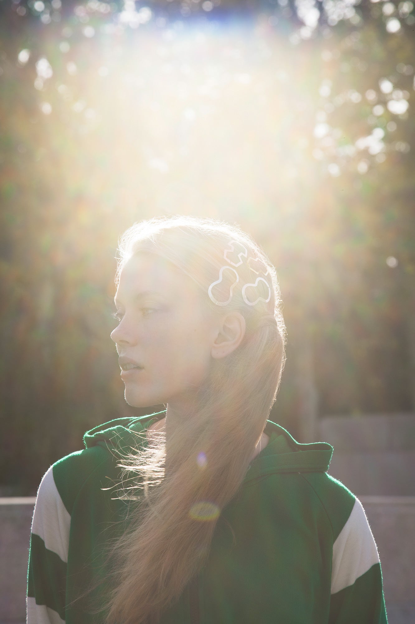 Sun drenched image of model wearing her hair in a low ponytail styled with designer hair clips BILLIE, MARIE and BIA by Clinq 