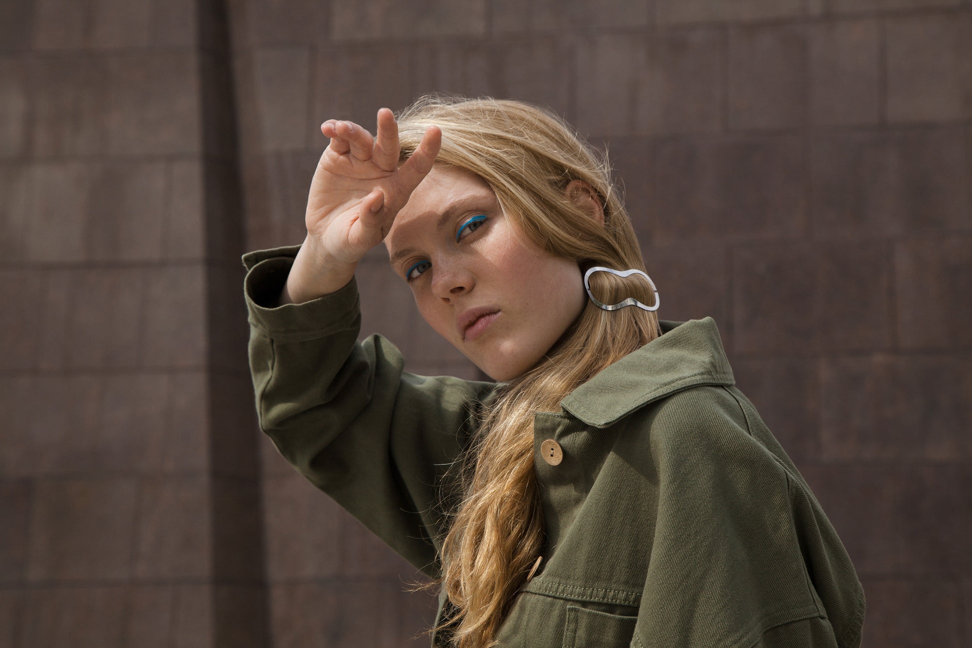 Portrait of model with blue eye shadow wearing her hair in a low side ponytail secured with minimalist barrette Elif by Clinq 