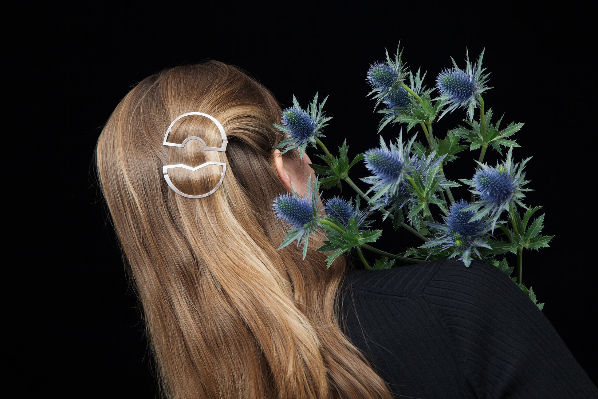 Back view of model wearing her hair down with one strand pulled back using the Carlina and Cynara designer hair clip by Clinq 