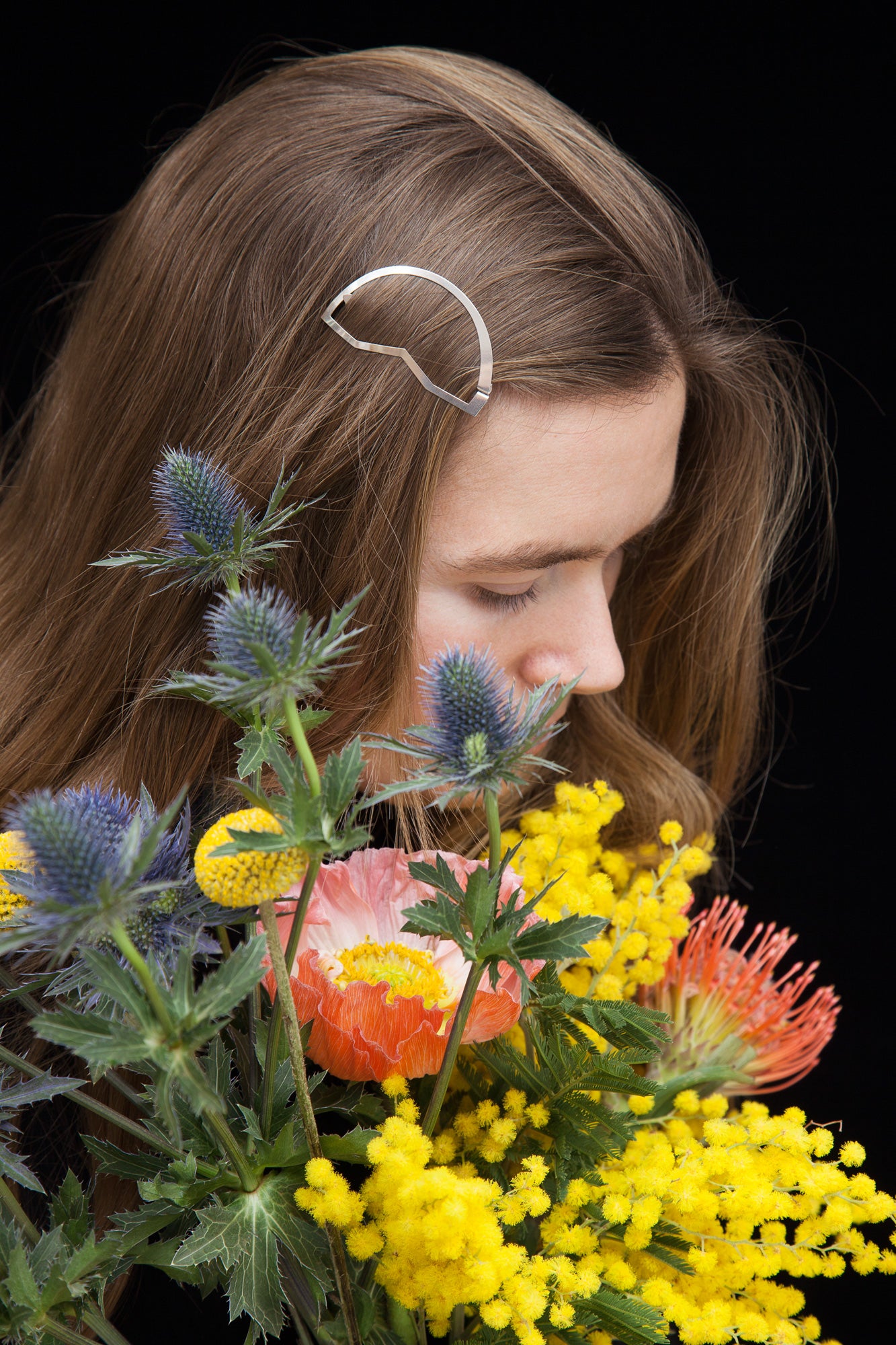 close up of model wearing designer hair clip Cynara as accent on the side