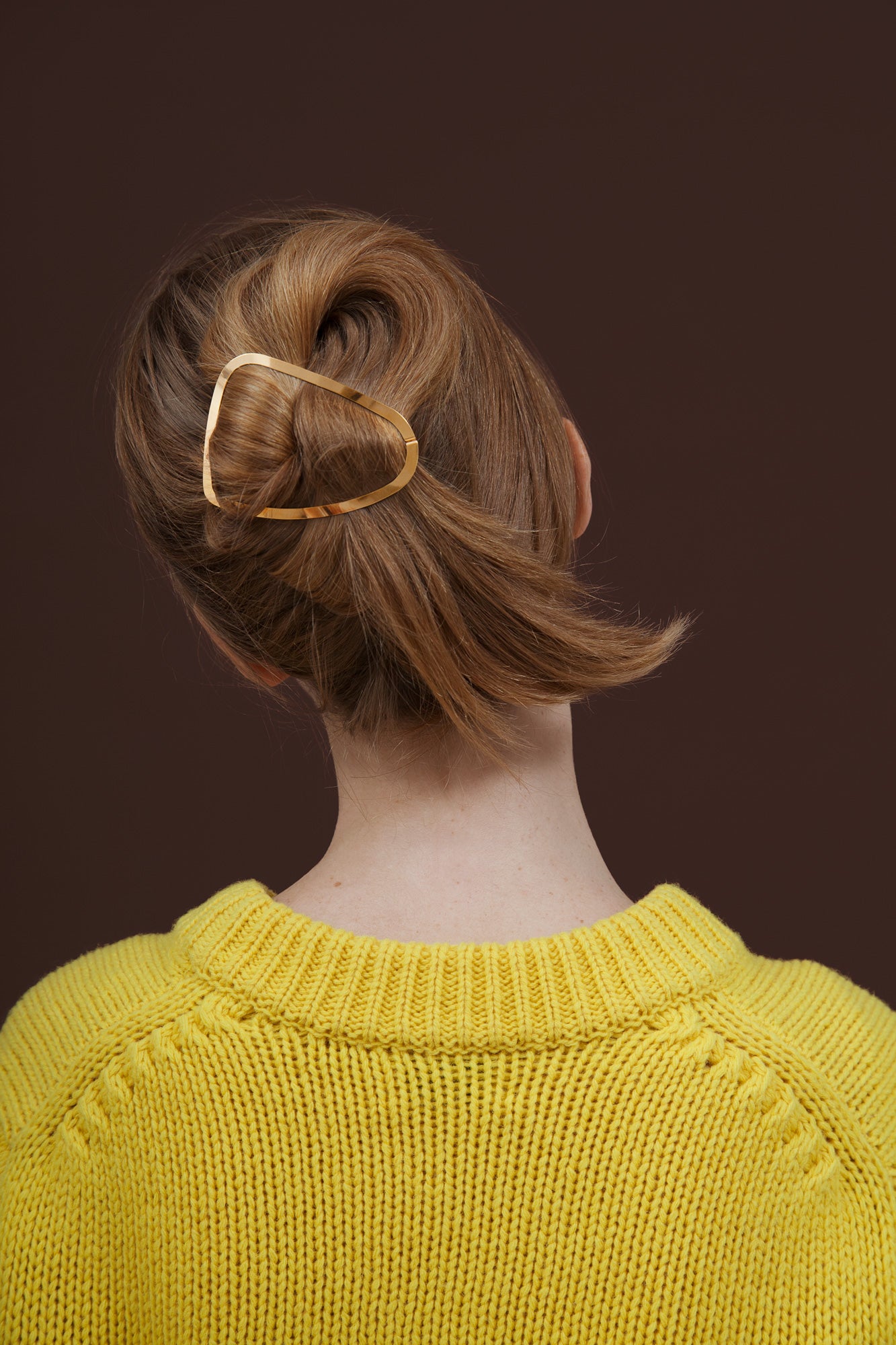 Back view of model wearing her hair in a twisted bun accessorized with designer hair clip Elissa by Clinq 