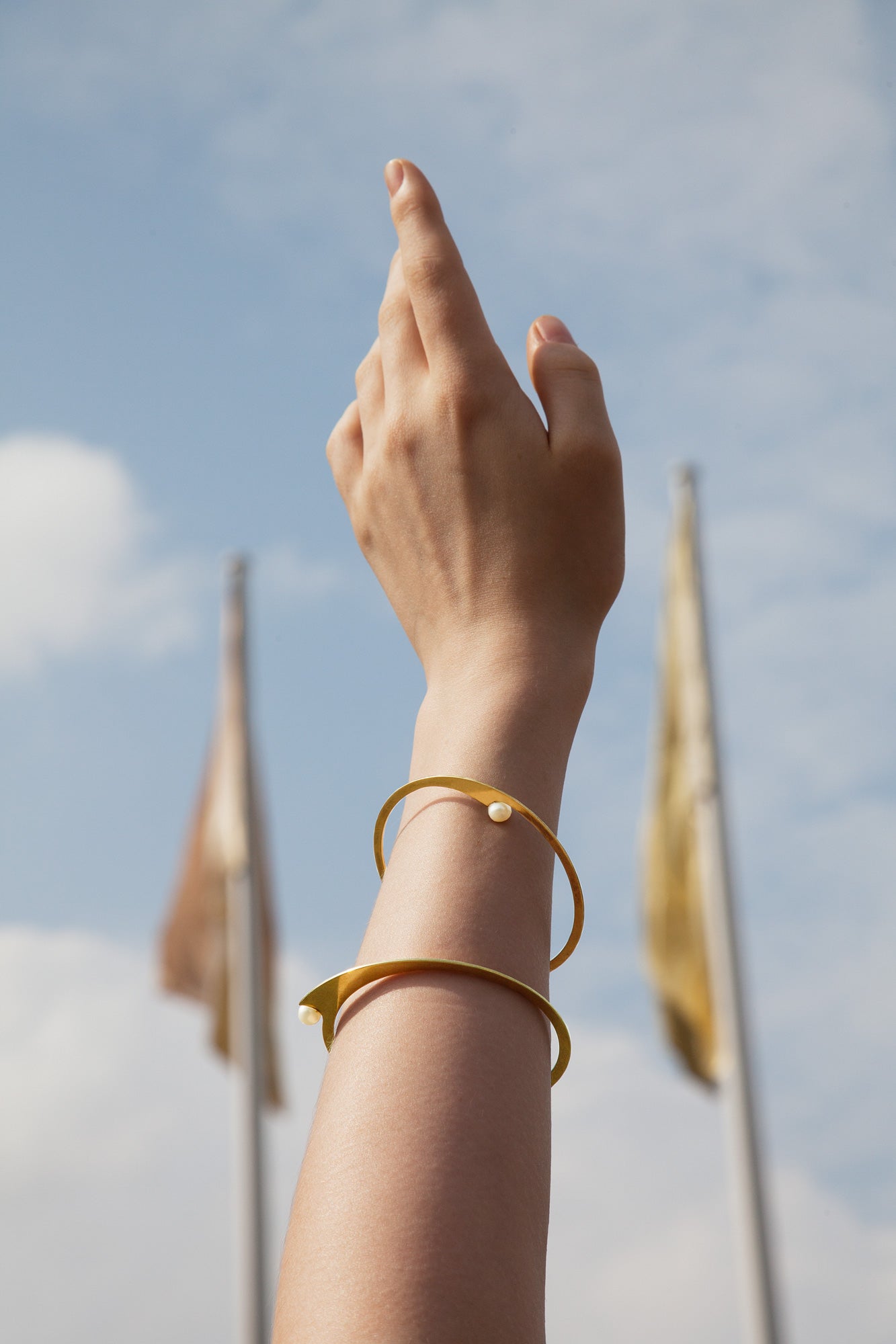 close up of an arm featuring designer slip on bracelts Dahlia and Liv by Clinq in Gold-plated